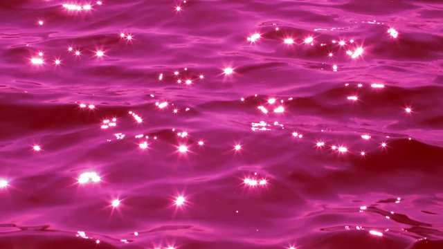 Liquid Fuchsia. Slow motion water with brilliant sparkles from sun. 