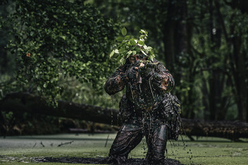 Portrait of a camouflaged soldier in swamp during patrol