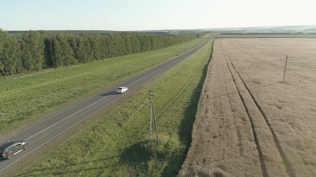 copter flight over the car in the field and on the highway