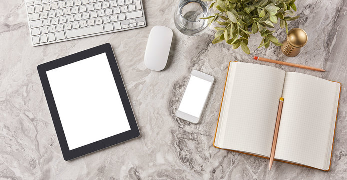 tablet on the marble background with technological tool and notebook pencil.