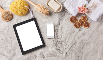 Fototapeta na wymiar bathroom products on the marble floor with tablet and smartphone isolated screen