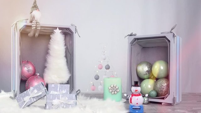 Eine Weihnachtsszene mit Pastell farbigen Elementen. Ein Schneemann wackelt mit den Armen.