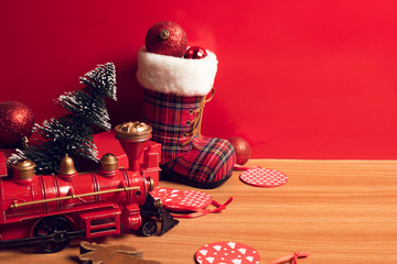 merry christmas with decor prop luxury toy and tree, train,snow boot,gloss ball on wood ground and red background