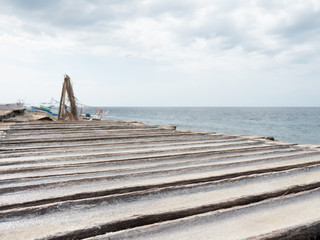 Production of sea salt in the Bali,Indonesia. Salt crystallizes out of the ground in salt farm,...