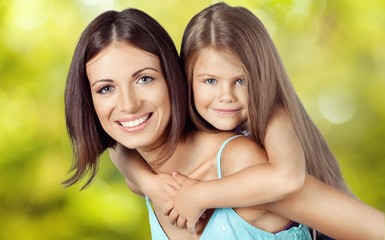 Young woman with little girl and beautiful flowers outdoors