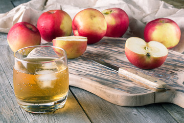 A glass of apple juice and fresh apples