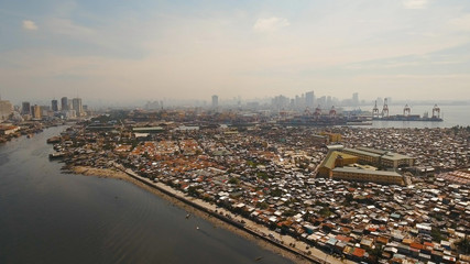 Aerial view poor district of Manila slums, ghettos, wooden old houses, shacks. Slum area of Manila, Philippines. Manila suburb, view from the plane.