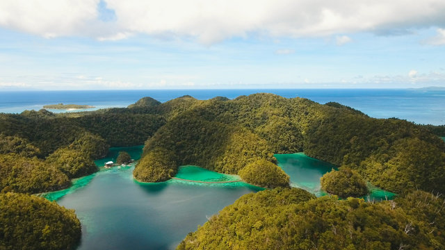 Aerial view: beach, tropical island, sea bay and lagoon, Siargao. Tropical landscape hill, clouds and mountains rocks with rainforest. Azure water of lagoon. Shore Landscape Bay. Travel concept.