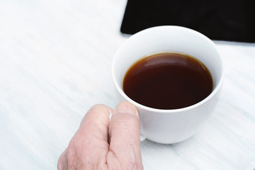 Close up of senior man holding cup of coffee