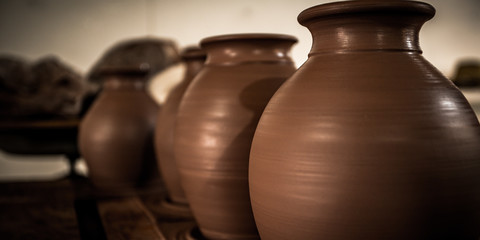 Fototapeta na wymiar New brown clay pots drying on a table