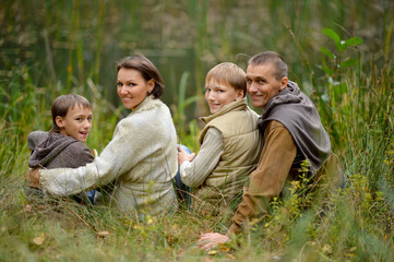 Naklejka na ściany i meble Portrait of cute family of four in park