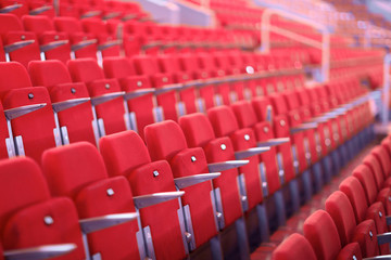 Fototapeta premium Rows of red numbered seats with armrests in a large auditorium