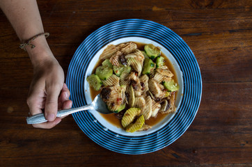RUJAK - woman eating traditional fruit and vegetable salad dish in Indonesia, one hand with spoon.