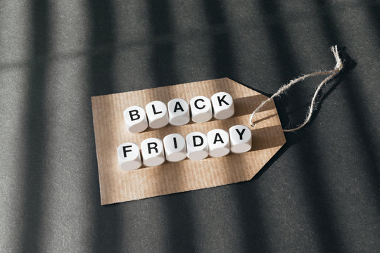 Sale banner with text word Black Friday on cardboard label on dark background. Black Friday sale concept
