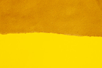 torn brown paper on yellow backgroung with copyspace