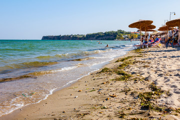 Umbrellas with loungers, chaise are placed next to the coastline, along water edge