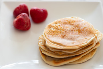 Pancakes stake with golden syrup and strawberries