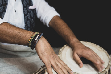 Images of a man's hands (wearing beads) playing the Tabla - Indian classical music percussion...