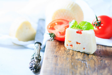 Homemade cheese with tomatoes on a light background. Copy space background.