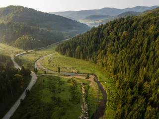 Road through mountains and forest captured from above