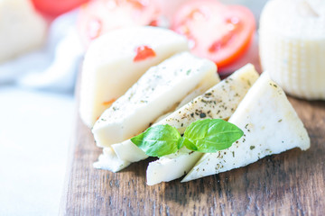 Homemade cheese halloumi with herbs on a light background. Copy space background.
