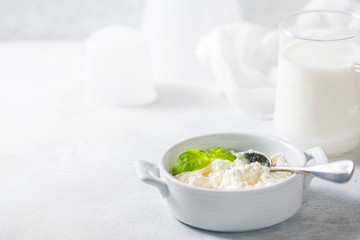 Homemade cottage cheese in a white bowl on a light background. Healthy breakfast.