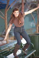 Young woman standing on a park bench