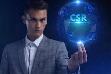 The concept of business, technology, the Internet and the network. A young entrepreneur working on a virtual screen of the future and sees the inscription: CSR