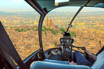 Helicopter cockpit flying on Montmartre hill skyline of Paris, French capital, Europe. Scenic flight above Sacre Coeur basilica, or sacred heart church on Montmartre hill.