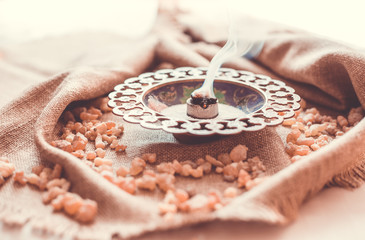 Frankincense burning on a hot coal. Frankincense is an aromatic resin, used for religious rites,...