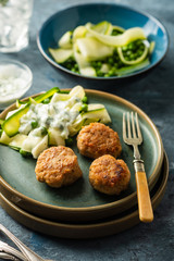 Chicken meat balls with zucchini salad and green peas, with garlic-yogurt sauce.