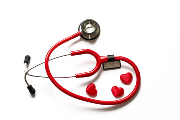 Diagnosis and treatment in cardiology. Medicine concept - Close up red stethoscope with name sticker and hearts isolated on white background. Copy space for text.