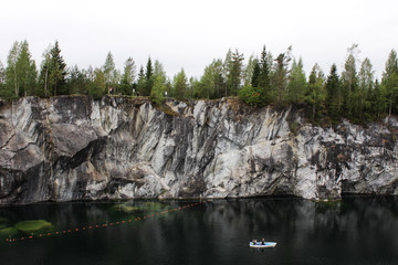 Fototapeta na wymiar Ruskeala marble quarry, Karelia, Russia. turquoise water in the river and gray with white veins of the shore, forest.