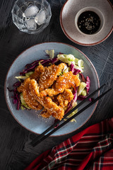 Salad with warm glazing chicken, sprinkled with sesame seeds. Chinese cuisine. Asian culture