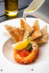 Salmon tartare with capers, lemon and red caviar.