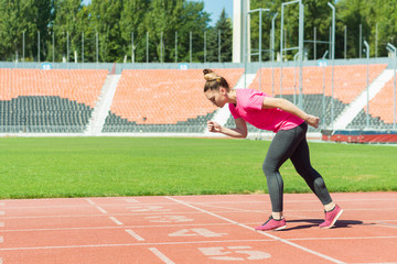 Obraz premium A young girl in the stadium is preparing to start.