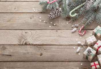 Christmas green branch and gifts on  wooden background