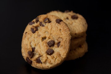Delicious chocolate cookies with hazelnuts and topping isolated over black board, copy space.