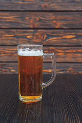 Close-up of a glass of beer on a wooden table. wooden background