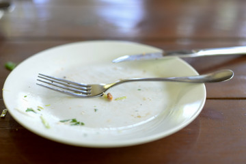 Empty dirty plates with forks and knife on the table.
