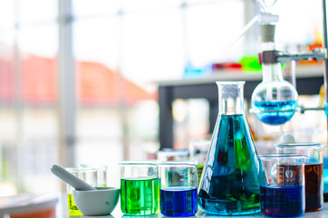 A pipette dropping sample into a test tube,abstract science background