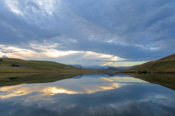 Clouds reflect on the water at sunset