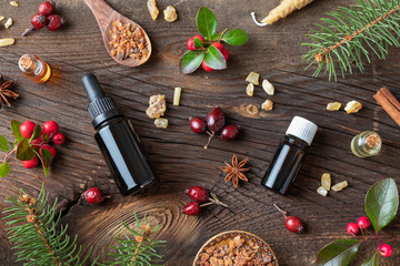Christmas background with essential oils, myrrh, frankincense, wintergreen twigs and Christmas spices