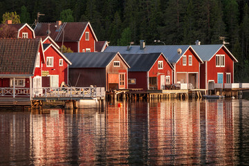 Fototapeta na wymiar red houses at sunset in the fishing village of Norfaellsviken, Höga Kusten, Sweden