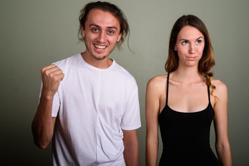 Young handsome man and young beautiful woman together against co