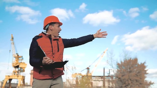 Engineering builder man Consulting People on construction site holding blueprint in his hand. Building inspector. Senior engineer Winter Jacket man in suit lifestyle and helmet outdoor . construction