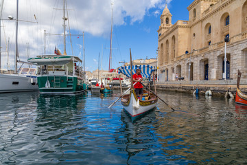 Birgu, Malta. Yachts and traditional Maltese boats dghajsa at the pier