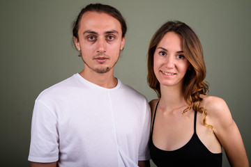 Young handsome man and young beautiful woman together against co