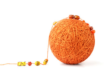 Orange big thread ball with  jewelry beads isolated on white background. Ball of cotton string with glass beads.