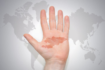 hand with map of kyrgyzstan on the gray world map background.